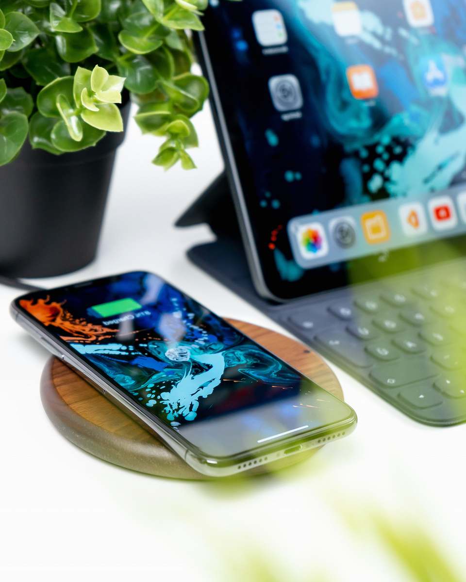 cell phone turned-on silver iPhone X beside iPad with keyboard mobile phone